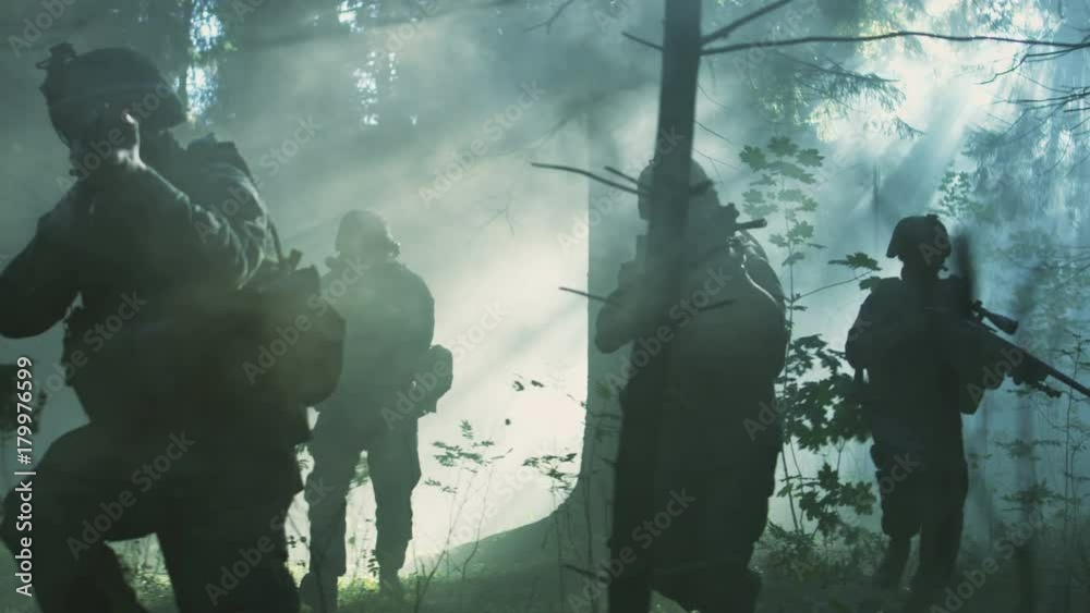 Fully Equipped Soldiers Wearing Camouflage Uniform Attacking Enemy, Rifles Ready to Shoot. Military Operation in Action, Squad Running in Formation Through Dense Smokey Forest. Slow Motion. 