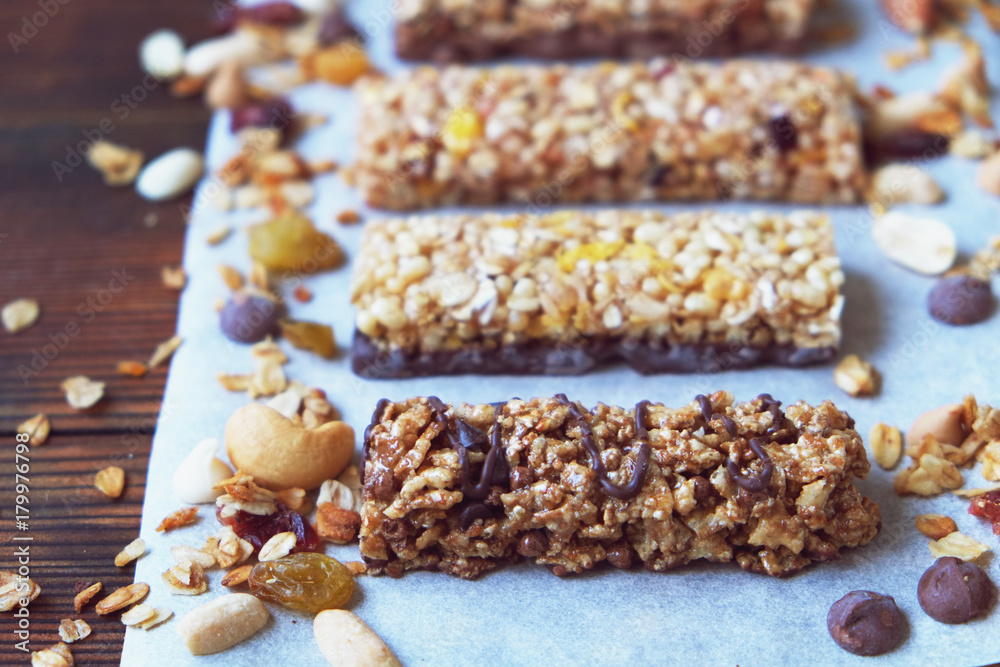 A variety of homemade granola bars, with nuts, raisins dried cherries and  chocolate.