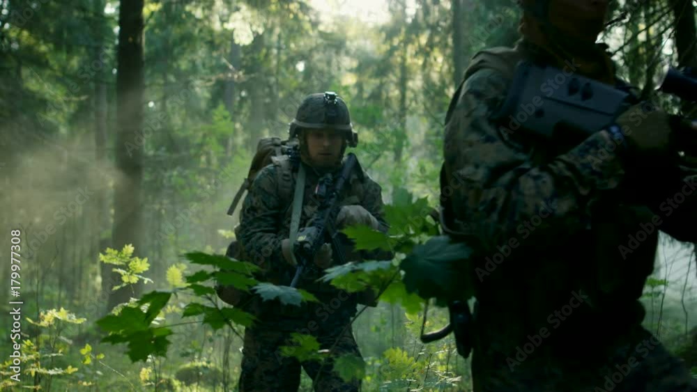Fully Equipped Soldiers Wearing Camouflage Uniform Attacking Enemy, Rifles Ready to Shoot. Military Operation in Action, Squad Running in Formation Through Dense Smokey Forest. Slow Motion Footage. Fully Equipped Soldiers Wearing Camouflage Uniform Attacking Enemy, Rifles Ready to Shoot. Military Operation in Action, Squad Running in Formation Through Dense Smokey Forest. Slow Motion Footage.