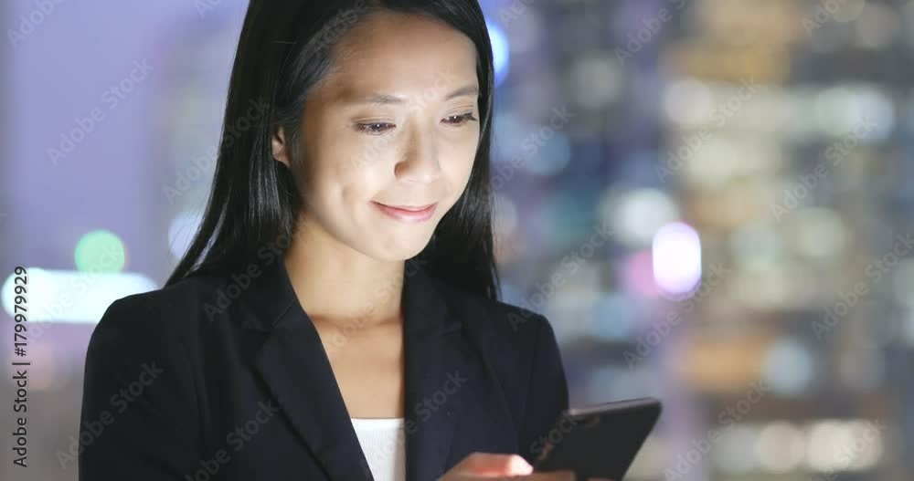 Businesswoman use of mobile phone in city at night Businesswoman use of mobile phone in city at night