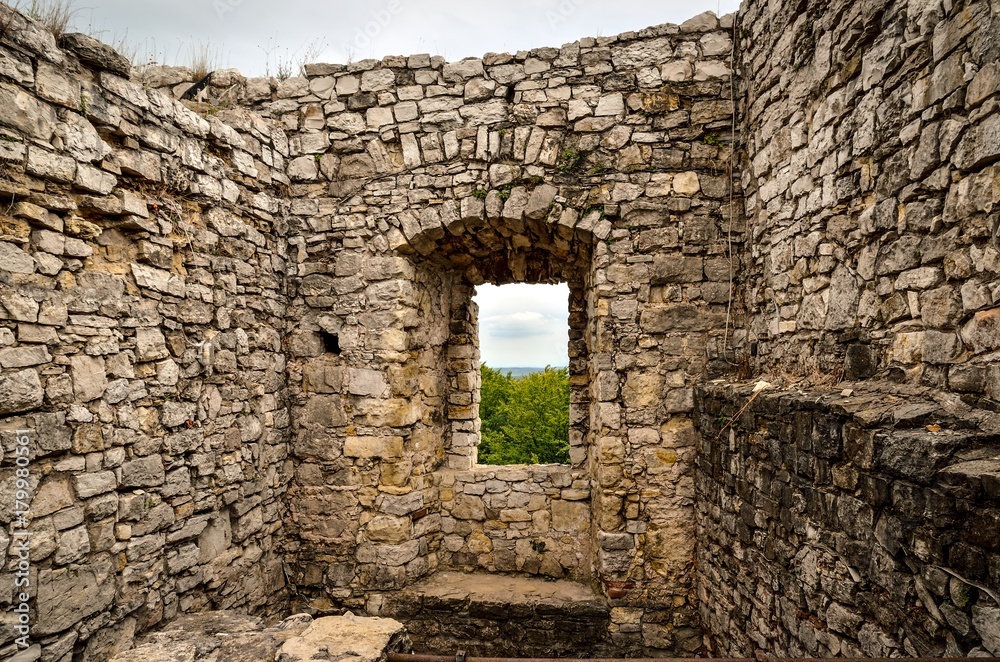 Window overlooking the green trees and mountains in the ruins of the castle. Old Lipowiec castle in Babice, Poland.