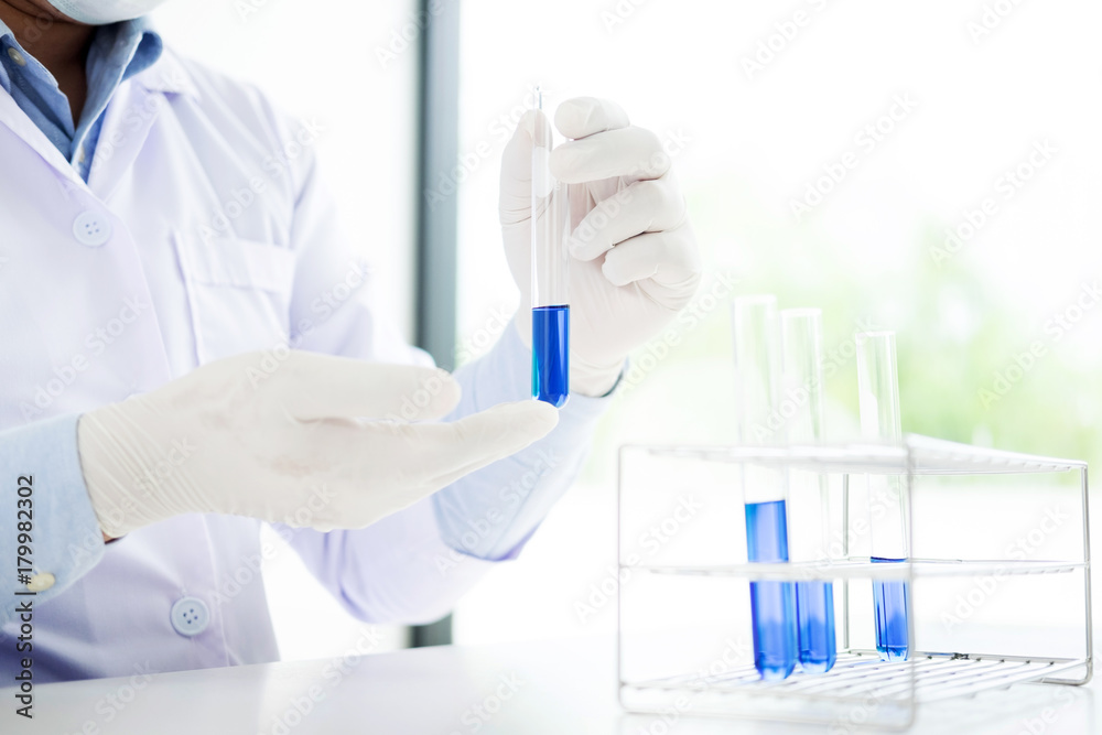 Asian scientific researcher working in laboratory holds test tube in hand a liquid solution analysis using chemical manufacturing. Asian scientific researcher working in laboratory holds test tube in hand a liquid solution analysis using chemical manufacturing.