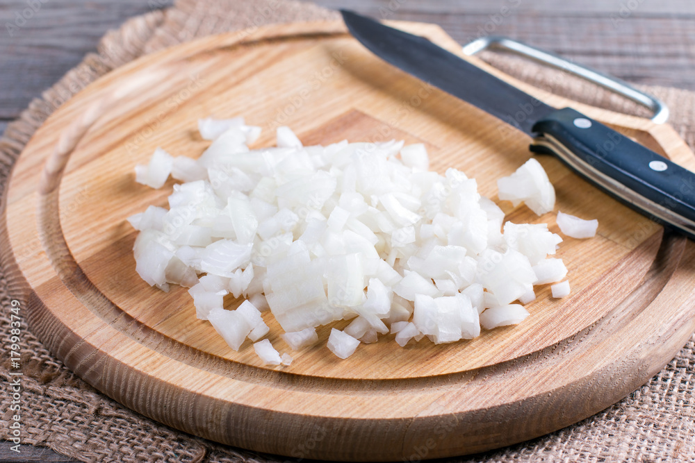 Raw onion, chopped very small cubes on a wooden board