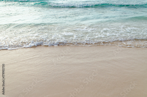 Close up Wave of The Ocean, White Sand on Summer Beach and Surface Water Foam.
