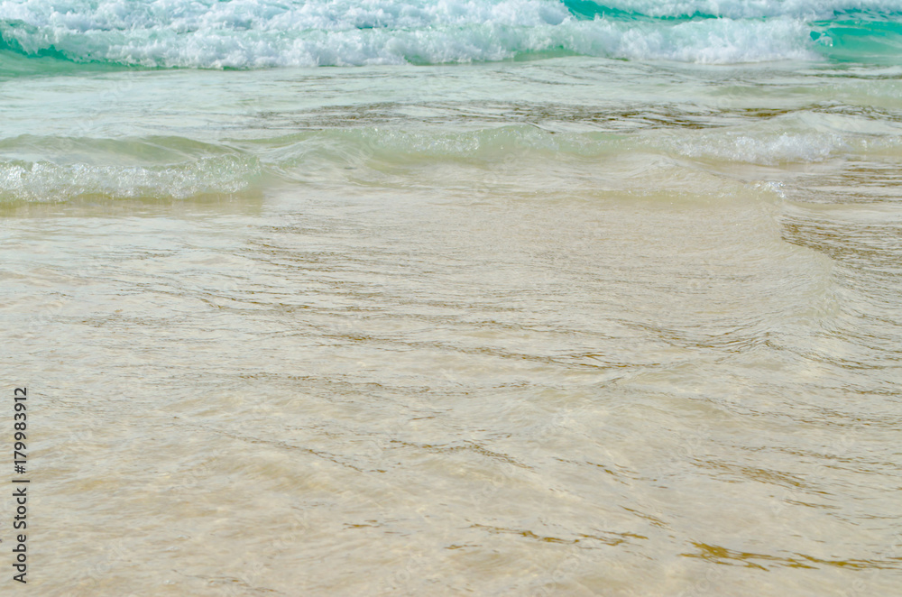 Close up Wave of The Ocean, White Sand on Summer Beach and Surface Water Foam. Close up Wave of The Ocean, White Sand on Summer Beach and Surface Water Foam.