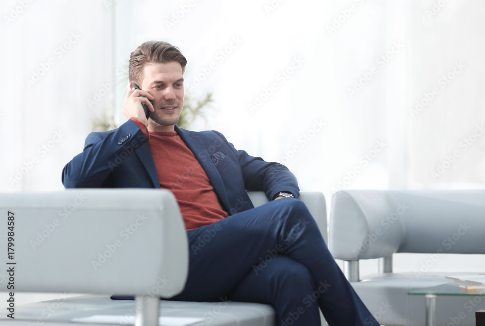 businessman talking on mobile phone sitting in a chair.