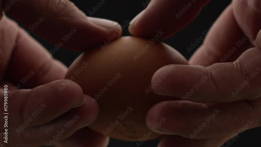 hands breaks the egg, yolk and protein flows out of the egg, frame close-up and slow-motion frame hands breaks the egg, yolk and protein flows out of the egg, frame close-up and slow-motion frame