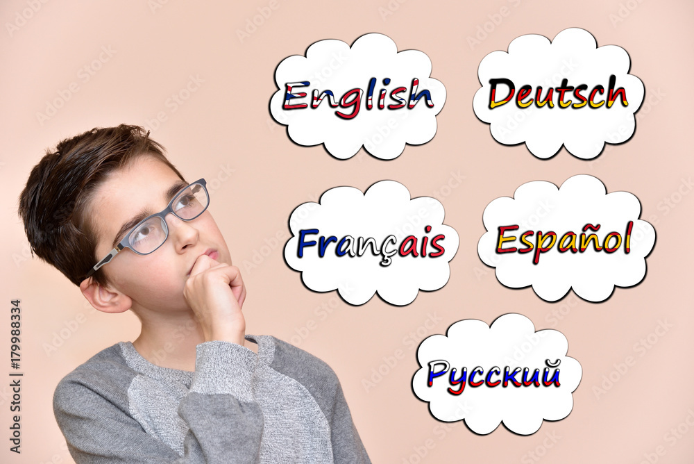 Thoughtful young boy thinking which languages to learn. Five different languages in the thought bubbles. Thoughtful young boy thinking which languages to learn. Five different languages in the thought bubbles.