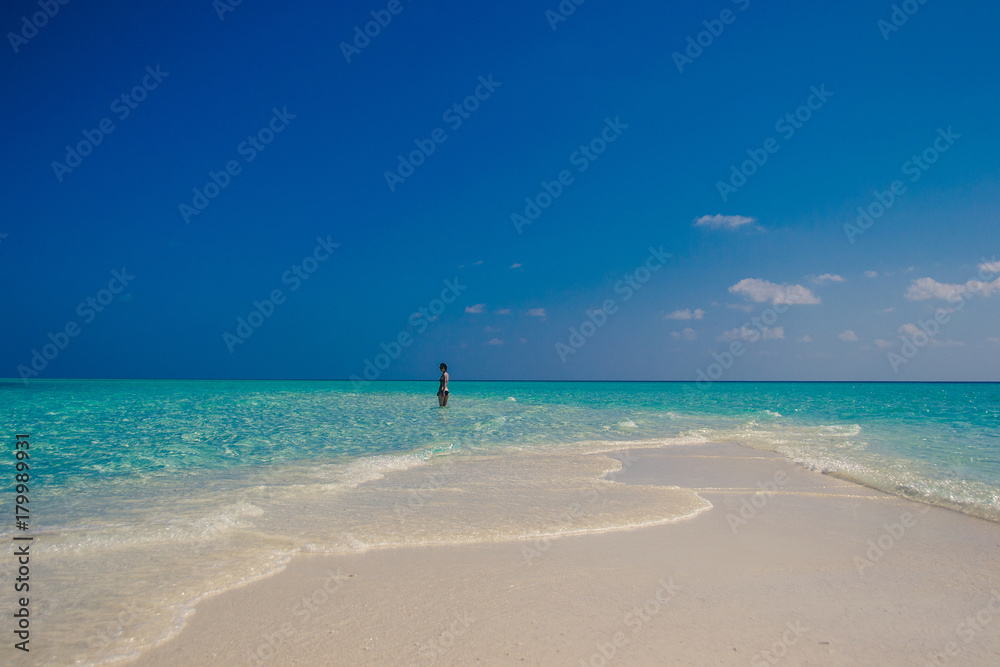 Idyllic paradise island landscape. Exotic tropical beach. Summer vacation, luxury holiday resort, tourism concept. Travel to Maldives. Seascape with white sand, turquoise water. Woman on background.