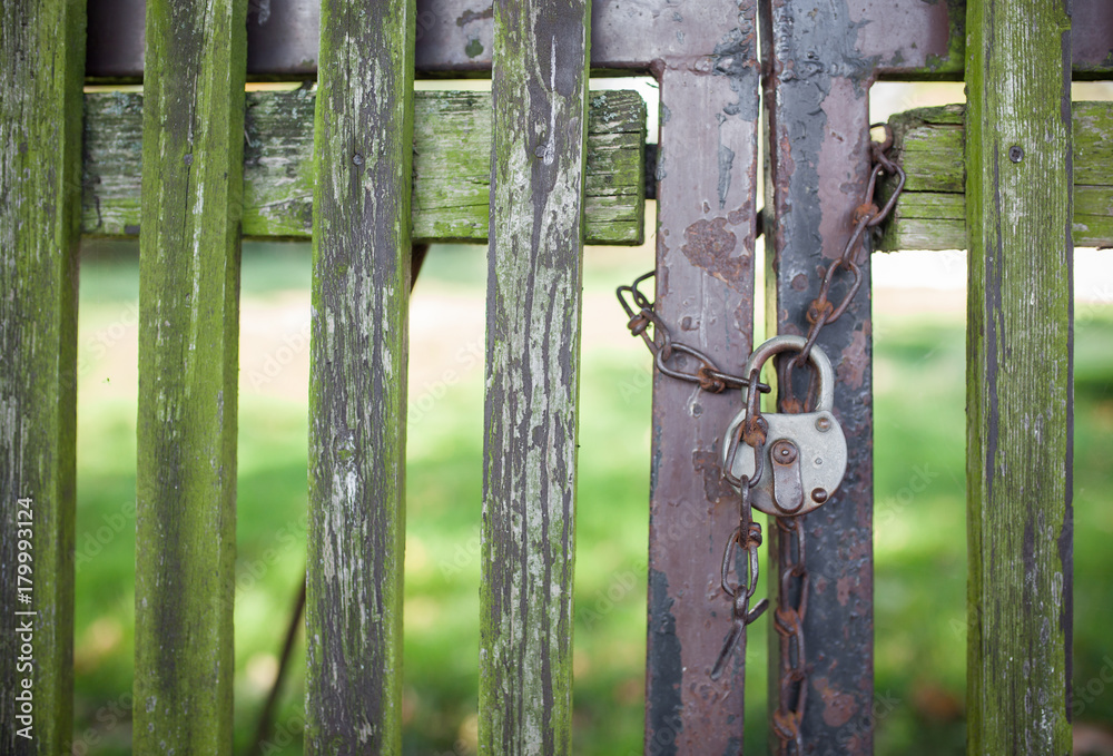 An old wooden fence closed with lock and chain