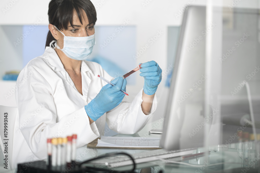 Woman examining test tube with liquid in laboratory Woman examining test tube with liquid in laboratory