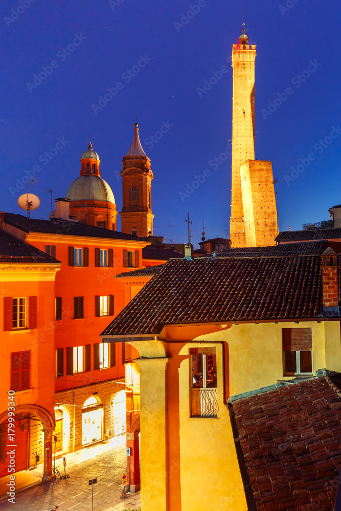 Aerial view of Two Towers, Asinelli and Garisenda, both of them leaning, symbol of Bologna and Church of Saints Bartholomew and Gaetano, during evening blue hour , Emilia-Romagna, Italy