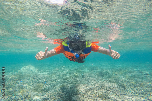 Woman is snorkeling in tropical sea for see coral reef at Gili meno. Lombok, Indonesia.