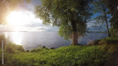 Calm and beautiful nature scene with sunset over lake in Sweden. Peaceful and idyllic summer landscape.