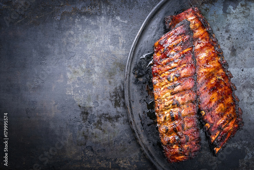 Barbecue pork spare ribs as top view on an old rustic board