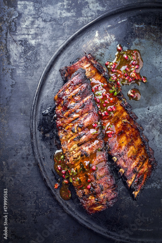 Barbecue Pork Spare Ribs with fruit relish as top view on an old rustic board