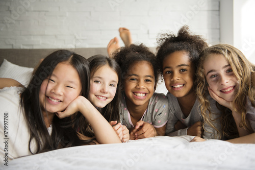 large group of her friends taking goog time on bed