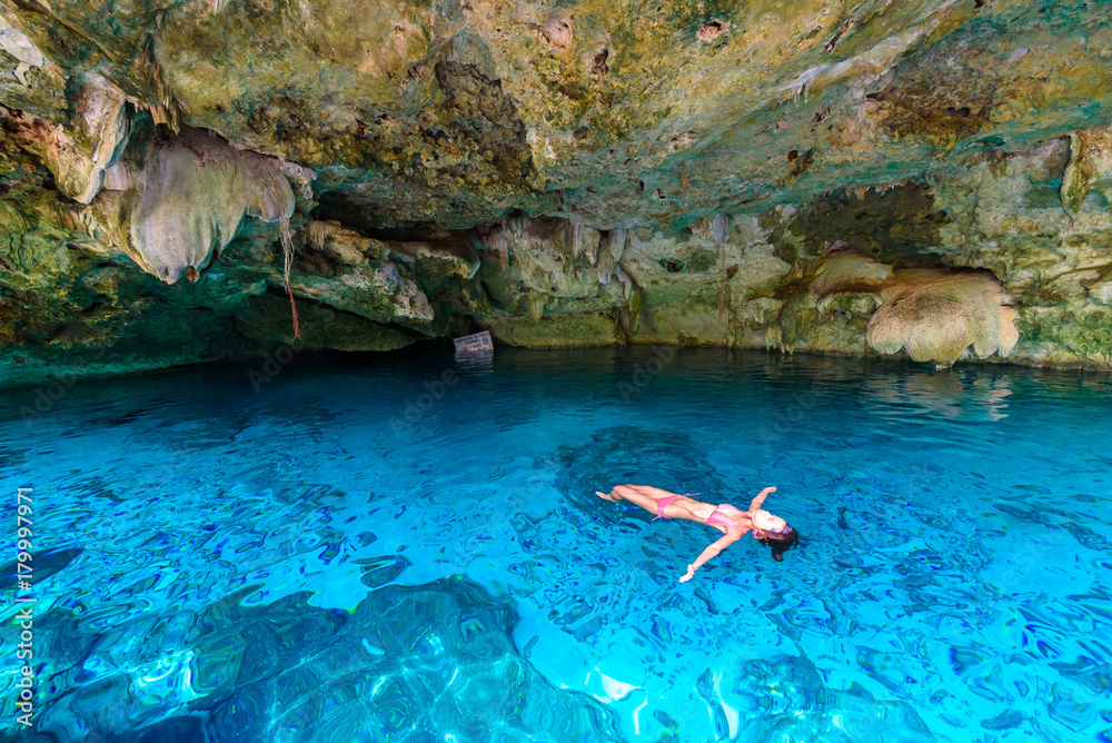 Fototapeta premium Cenote Dos Ojos in Quintana Roo, Mexico. People swimming and snorkeling in clear blue water. This cenote is located close to Tulum in Yucatan peninsula, Mexico.