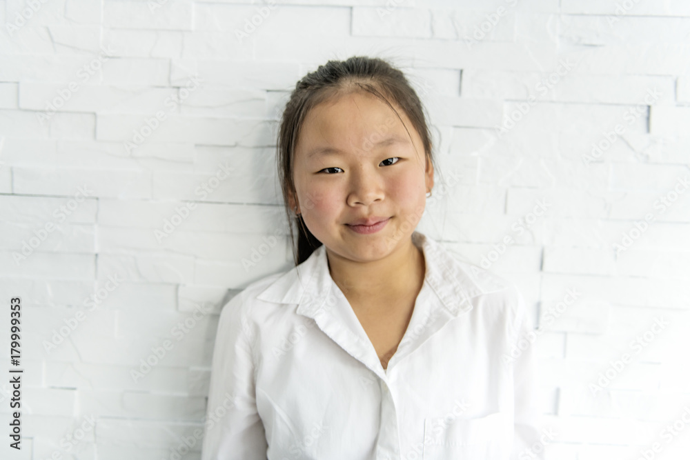Cute pretty asian child girl near light brick wall Cute pretty asian child girl near light brick wall