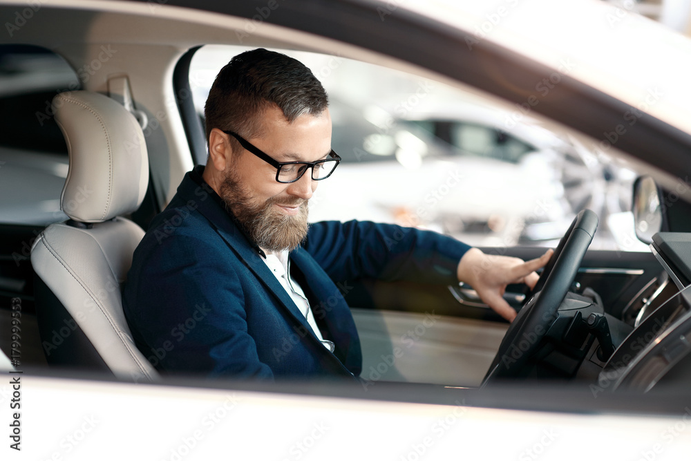 Buyer looking at car interior. Car dealership.