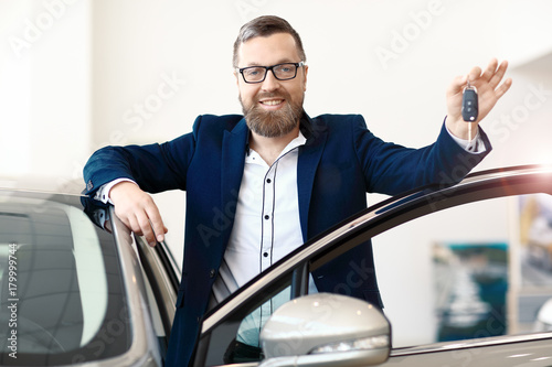 Happy male buyer is showing new car key. Focus on the Face. © Mr. Music
