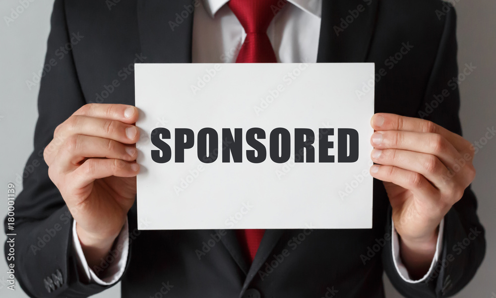 Businessman holding a card with text SPONSORED Businessman holding a card with text SPONSORED