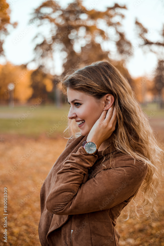Profile of young woman posing in autumn park.
