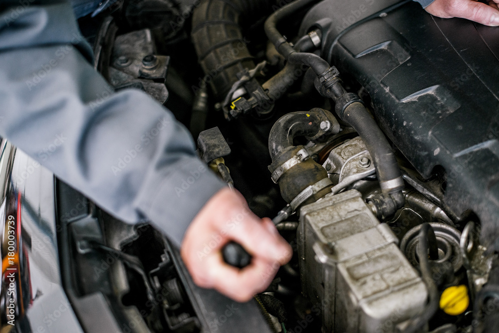 Close up hands of mechanic doing car service and maintenance. Close up hands of mechanic doing car service and maintenance.