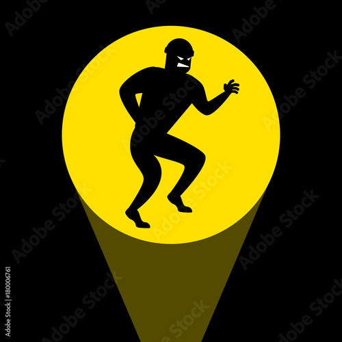 Silhouette of thief that sneaks in the light of a flashlight