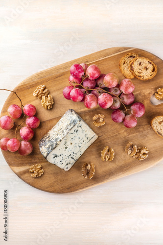 Blue cheese with grapes, nuts, toasts, and copyspace