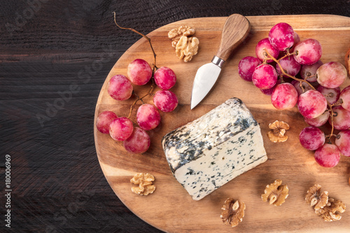 Blue cheese with grapes and copyspace on rustic textures