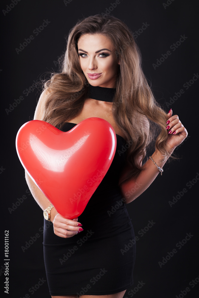 Sexy woman in black dress holding a red heart balloon. Sexy woman in black dress holding a red heart balloon.