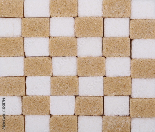 Brown cane and white sugar cubes background and texture