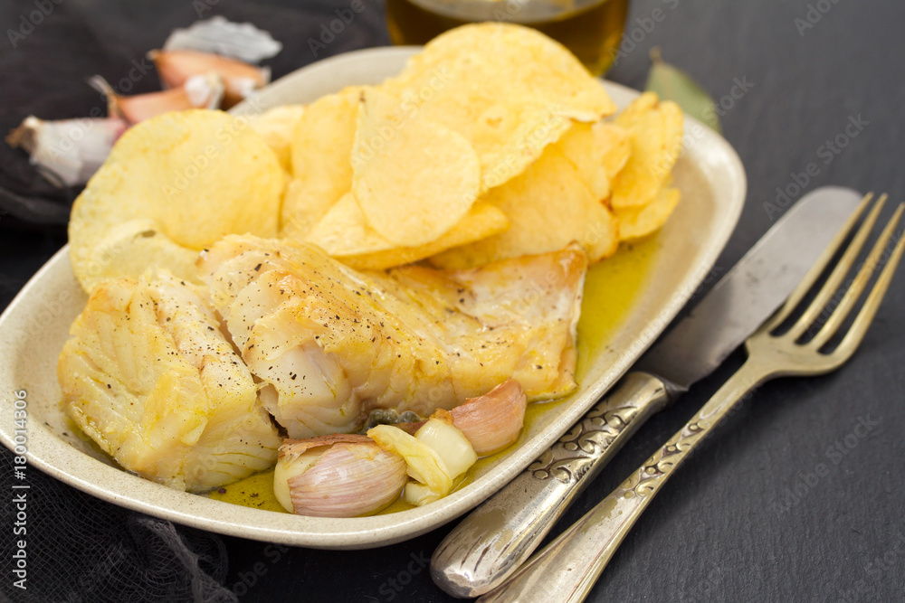 fried codfish with garlic and potato on dish fried codfish with garlic and potato on dish