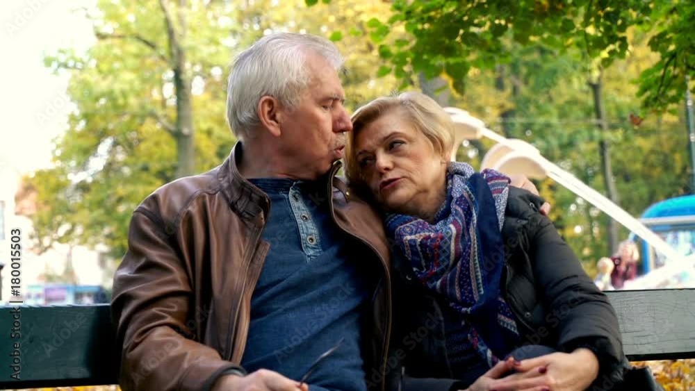 Portrait of middle aged, happy couple sitting on a bench park
Portrait of middle aged, happy couple sitting on a bench park