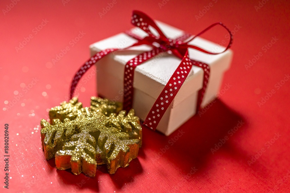 White gift box with red ribbon isolated on red color background. Merry Christmas and Happy Holidays concept.