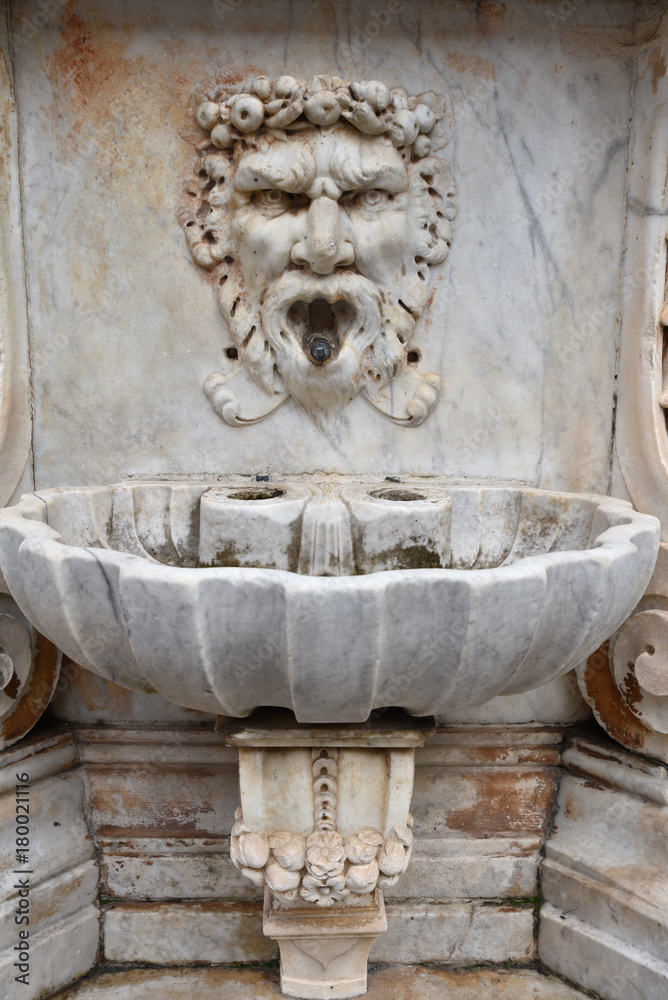 Fontaine en marbre à tête grotesque à Pise en Italie, France