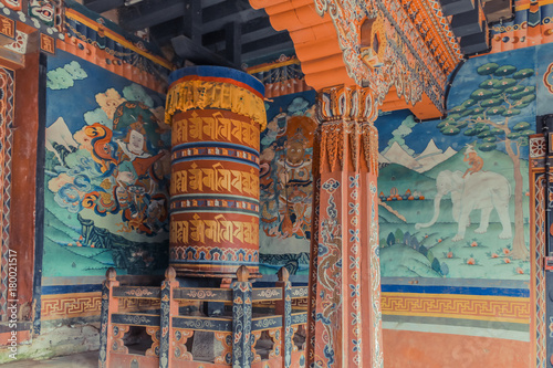 Wall paintings and large prayer wheel inside the portico of the Trongsa Dzong, Bumthang, Bhutan.