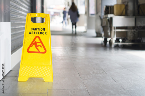 yellow sign inside building hallway showing warning of caution wet floor,selective focus,vintage color.
