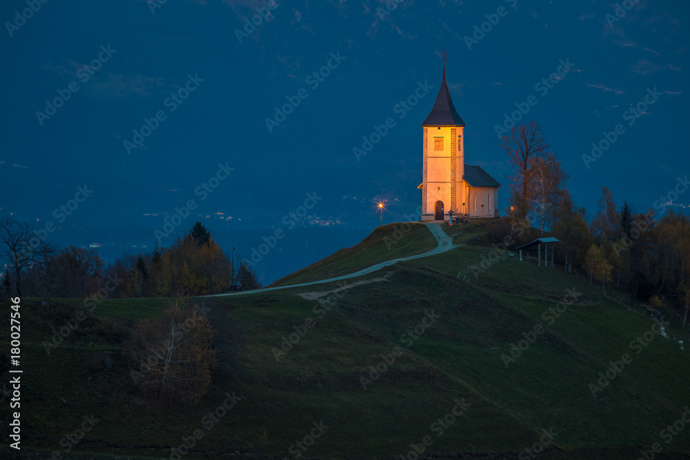 Jamnik, Slovenia - Blue hour at Jamnik with illuminated St. Primoz church. Julian Alps at background