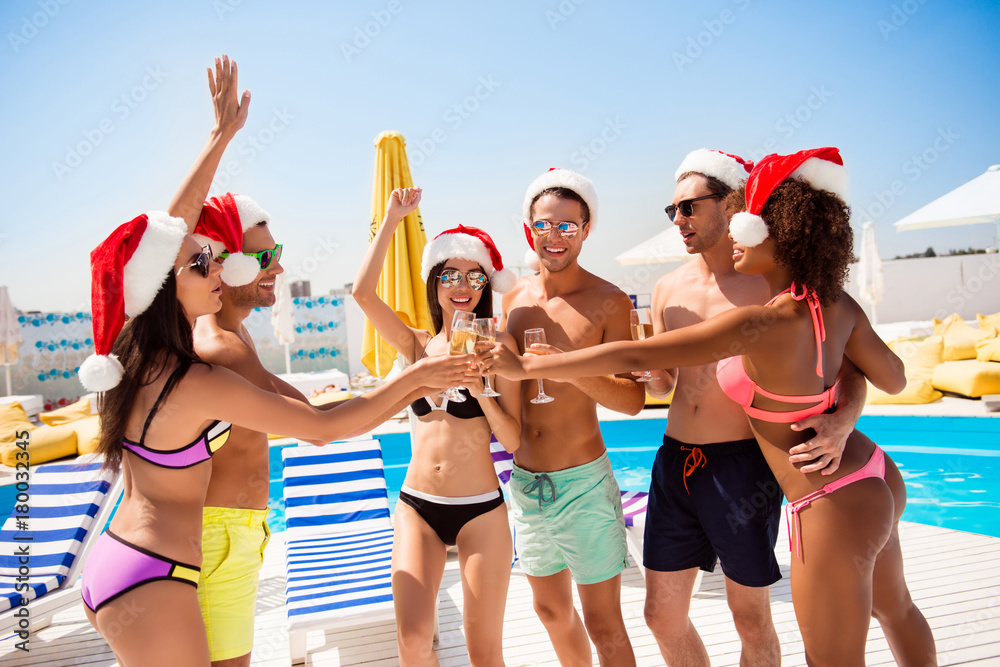 Crazy seasonal feast at beach resort. Six international hot teens students in diverse swim wear and spectacles have drinks near pool, sunshine, holiday together, x mas noel mode