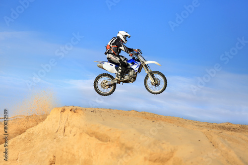 Enduro, motocyklista na motorze crossowym w czasie skoku.