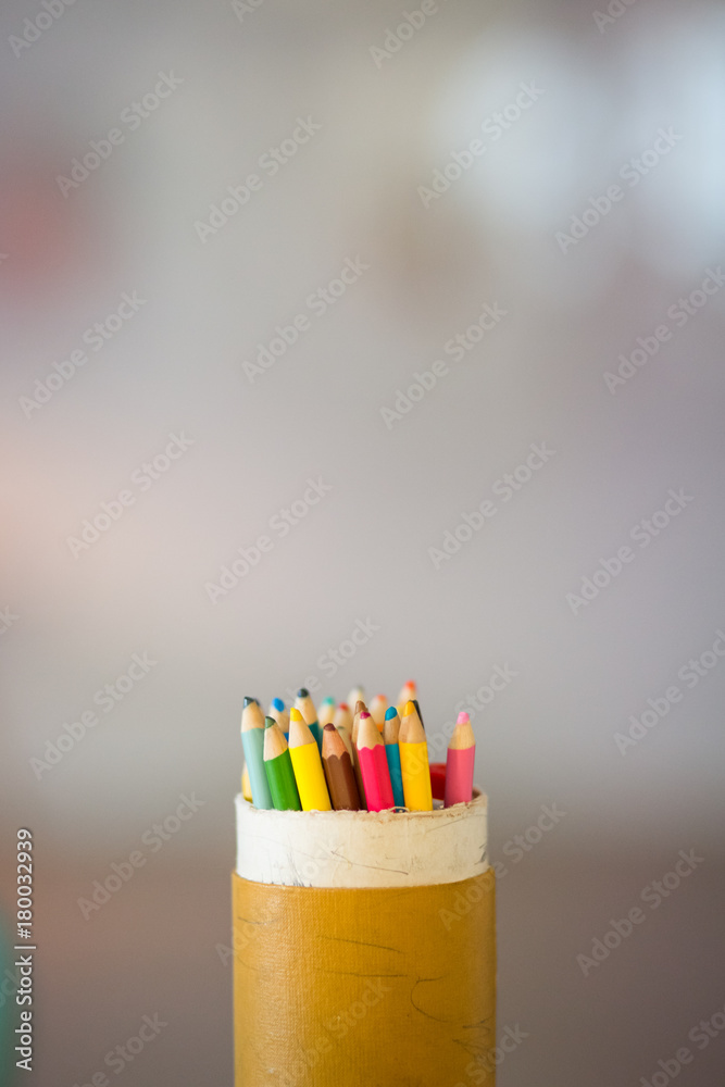 colored pencils in a can with negative space around and blurred background