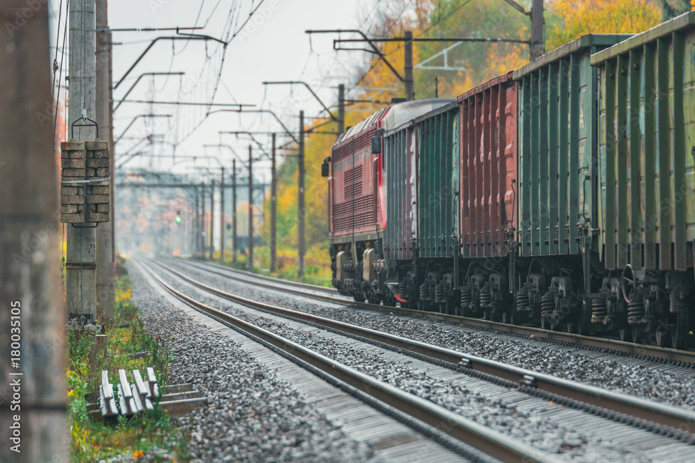 Obraz premium Railroad going along the colorful forest in Autumn. Leaves have changed colors and creates a wonderful Autumn scenery along the Railway infrastructure.