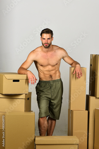 Sexuality and moving in concept: sexy man among boxes.