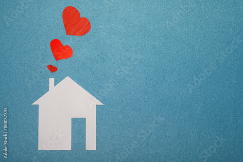 Obraz na płótnie Concept of love in house. White paper house on blue textured background with red hearts from pipe. Smoke from pipe in form of paper red hearts. LOVE, family, home. w salonie