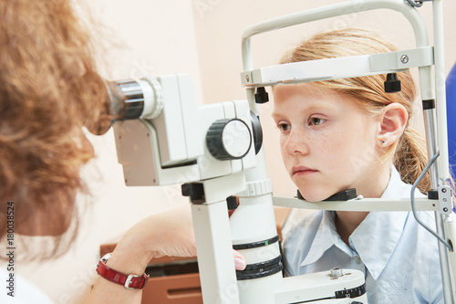 child ophthalmology. female doctor checks eyesight at girl