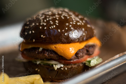 Black double hamburger made from beef, cheese and vegetables. photo