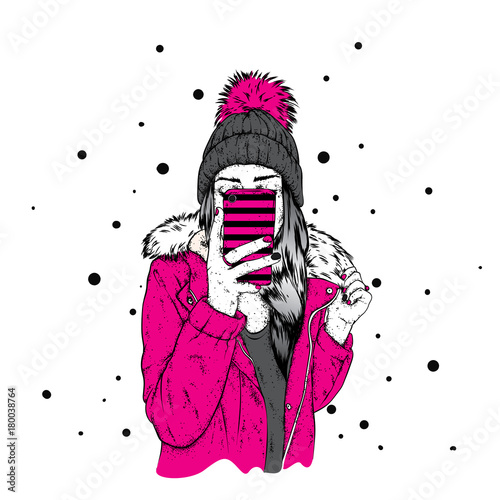 A girl in a stylish down jacket and a beautiful hat with a fluffy bubo. A woman is holding a smartphone and making selfies. Vector illustration. Clothing and accessories, fashion and style.