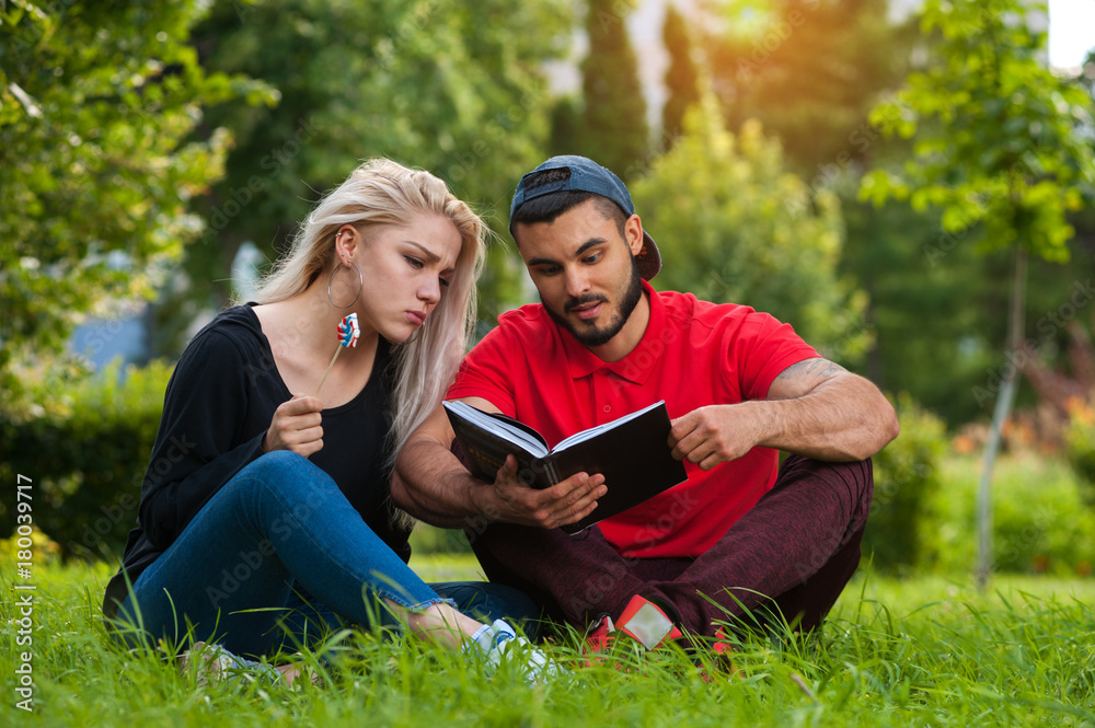 Romantic couple reading book together in park